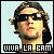 Pixelated static image of a person with long dark hair wearing black sunglasses, set against a light blue background with bold text reading "VIVA LA BAM" at the bottom.
