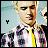 Pixelated static image of a person in formal attire with a yellow tie, standing beside another figure against a light blue background.