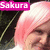 Pixelated image of a person with short pink hair, smiling, with a pink text label reading "Sakura" in the top-left corner.
