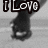 Pixelated black-and-white image showing a stylized figure with a large head and body, partially obscured text above reading "I Love" in blocky letters.