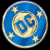 Pixelated circular icon depicting a blue and beige spiral galaxy with yellow stars on black background.