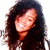A person with long dark hair smiling, shown in four positions with slight variations in head angle and expression