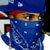 Static pixelated image of a person wearing blue headwear and face covering with red accents, partially visible eyes, and white highlights on the fabric.