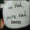 A circular white surface displays handwritten text with a black 'lets hug' label on the left and pink 'lets hug' label on the right.