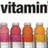 Pixelated image with four lipstick tubes, partial text 'vitamin' top-left, 'looks.' top-right, 'yummy.' bottom-left on pink and gray backgrounds.