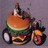 Pixelated orange and green vehicle with circular wheels and a small figure on top, set against a muted purple background.