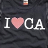 Static image of a dark fabric with white text and pink heart symbol, featuring 'I ❤️ CA' above 'HOLLISTER' in pixelated font.