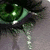 A pixelated image shows a green eye with a black pupil on the left, next to green text on a black background reading "It's more like, behind these green eyes" with a faint eye outline in the background.