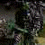 Animated sequence showing a dark, shadowy figure with glowing eyes and mouth against a blurred green background.