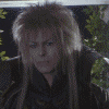 A person with tousled light brown hair wears a dark high-collared outfit against green foliage, showing subtle facial expression changes across frames.