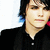 Two side-by-side pixelated images of a person with dark hair and black clothing against a white background, the right image showing slightly different facial features and a pink/red element on the right edge.