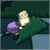 Pixelated icon shows a figure with purple hair and light-colored clothing on a dark green background.