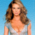 Pixelated image of a woman with long brown hair wearing a light-colored low-cut top against a blue background.