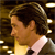 Pixelated profile view of a person with dark hair wearing a light-colored shirt against a dark background with scattered light spots.