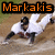 Pixelated image shows a figure in white clothing with dark limbs performing an action on a brown ground, beneath orange text reading 'Markakis' against black background.