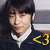 Pixelated portrait of a person with dark hair wearing a white-collared shirt and dark jacket, yellow '43' symbol on right side.