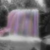 A blurry static image of a figure with pink and purple vertical stripes against a dark background.