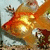 Pixelated image of a stylized orange and red fox head with glowing yellow eyes against a light blue background.