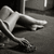 Pixelated grayscale image of a figure in dynamic pose with extended limbs against dark background.