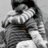 Two figures embrace in grayscale; one wears striped clothing, the other a light top. A second view shows the same figures from a different angle with a blue background.