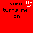 Red background with black pixelated text reading 'sara turns me on' and a white heart symbol replacing the letter O in 'on'.