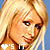 Pixelated close-up of a blonde woman's face with two distinct mouth expressions, left side showing closed lips and right side showing open smile.