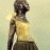 Pixelated figure in profile view wearing a yellow sleeveless top and dark lower garment against light background.