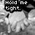 Pixelated grayscale image shows a figure with arms raised, overlaid by a black speech bubble containing white text "Hold me tight."
