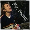 A person with long brown hair wearing a dark blue sweater with red and yellow stripes holds a small object while text reads 'Mr. Feeny!' in white letters on a dark background.