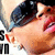 Pixelated close-up of a person with dark hair and light skin, mouth open in an expressive pose against a blurred background.