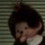 Animated icon of a cartoon character with dark hair and red bow, wearing white collar, against striped background.