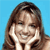 Static pixelated image of a person with long brown hair against solid blue background, hands near face in relaxed pose.