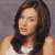 Static pixelated image of a person with long dark hair wearing a white sleeveless top against a gray background.