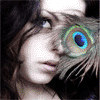 A person with dark hair and a white headband wears a peacock feather over one eye, with blue and green iridescent patterns visible.