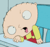Animated cartoon baby in red overalls and yellow shirt leaning on blue table with hand movements.
