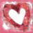 A static pixelated image of a heart shape formed by swirling red and pink hues against a matching background, with a bright white center.