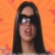 A four- shows a person with long dark hair and sunglasses against an orange background, with the bottom-right displaying text