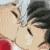 Two anime-style characters in close proximity, one with dark hair and the other with light hair, sharing a kiss against a blurred background.