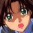 Anime-style character with brown hair and green eyes, wearing blue clothing, next to black background with white text.