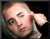 A pixelated contact sheet of two animated frames showing a person's face on the left and green text on a dark background on the right, with visible dithering and low-resolution rendering artifacts.