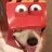 Pixelated red cartoon character with large white eyes and black pupils, a wide red mouth, and a white lower face with a dark nose and visible tongue.