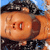 Pixelated close-up of a cartoon character's face with orange skin, dark hair, and visible eyes against a blue sky background.