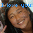 Pixelated image of a person with dark hair smiling, wearing a black top, and holding an object near their face under blue text reading "I love you!".