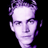 Pixelated static icon of a person's face with purple and white tones on black background, rendered in low-resolution style typical of early 2000s instant messaging avatars.