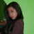 A person with long dark hair in a brown top against green background, shown across four with subtle pose and expression shifts