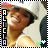 Pixelated image of a person with brown hair wearing a white top, surrounded by colored hearts and a vertical name banner.