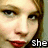 A four- shows a person with light brown hair and red lipstick, each displaying text that reads 'she', 'Loves', 'Me!', and the full phrase