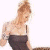 Pixelated image of a woman with blonde hair in an updo wearing a dark strapless dress, standing against white background next to green text reading 'Original Icons .com'.