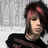 Pixelated static image of a person with dark hair and a red bow, wearing a dark top against a light gray background.