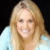 Static pixelated image of a person with long blonde hair wearing light blue clothing against dark background.
